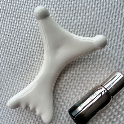 OEM/ODM Ceramica a forma di X Gua Sha Scraping Massaggiatore Salone di bellezza Essenziale per il rilassamento facciale
